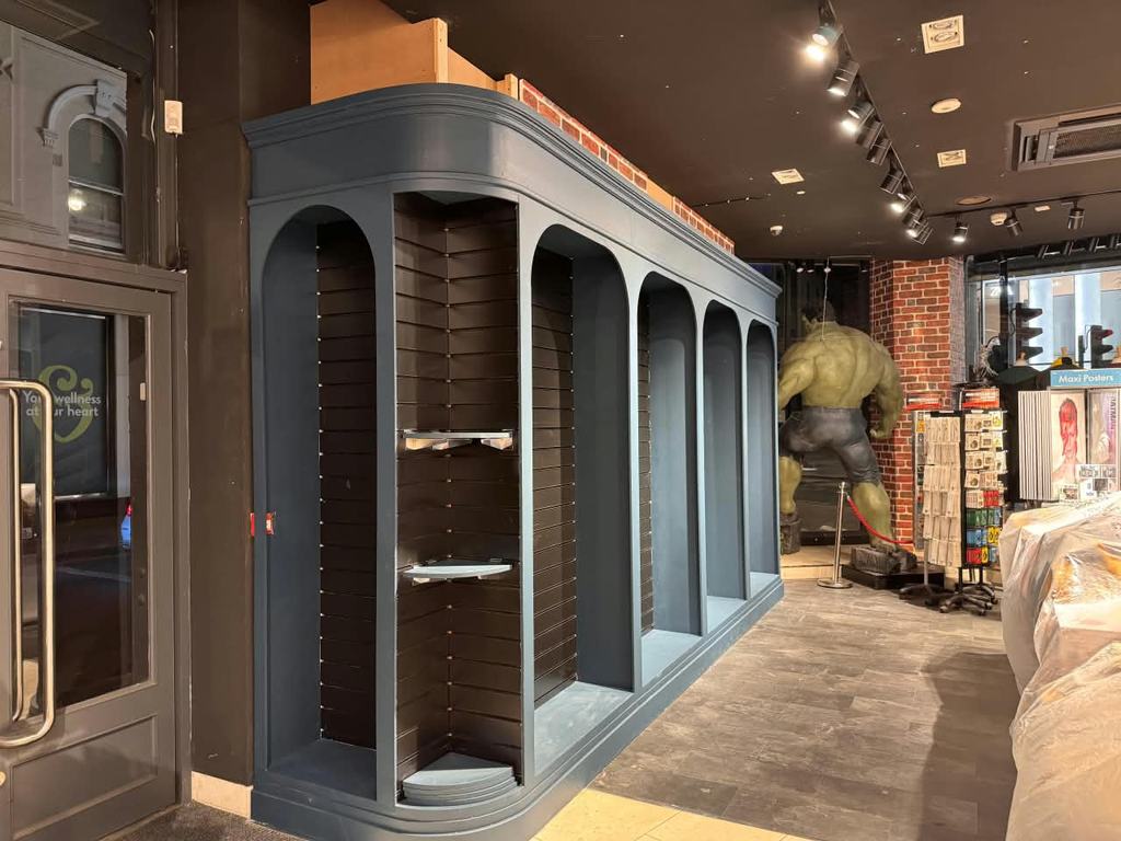 Completed arched display unit painted slate blue, installed against the shopfront.