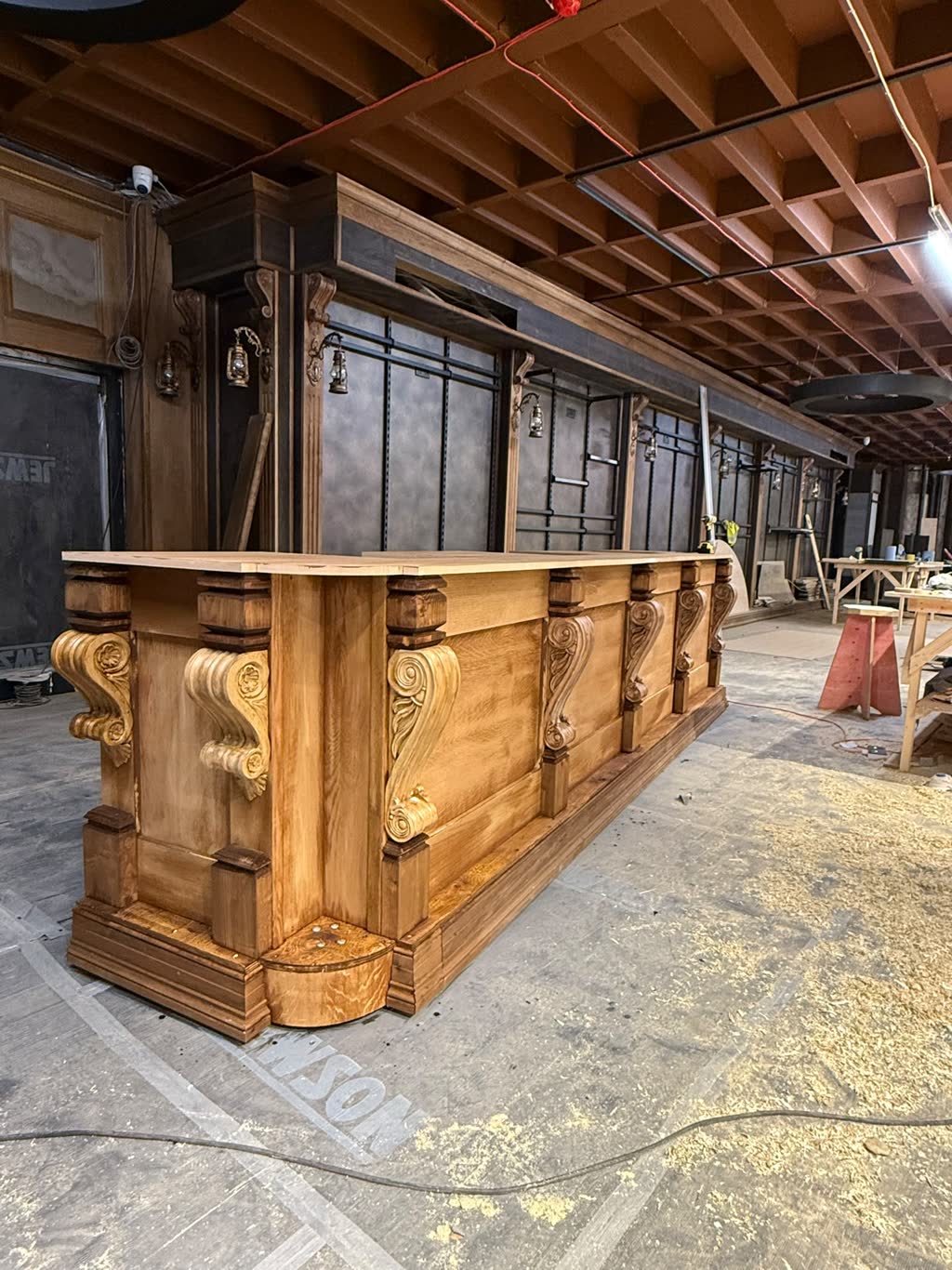 A large oak counter with carved scroll corbels, photographed mid-build in the workshop.