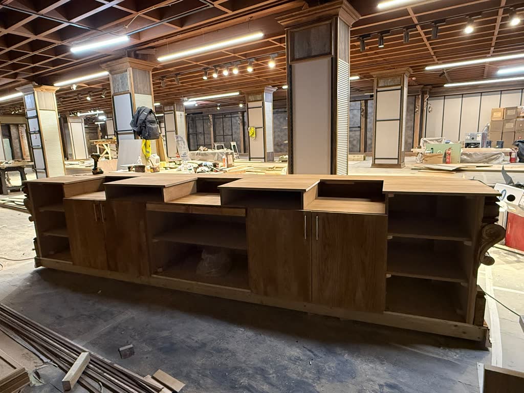 A long timber servery under construction on a large fit-out floor, Northstead’s own joinery.